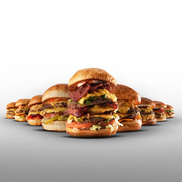 A line of various Burger Truck burgers, with a large, stacked burger in the foreground.