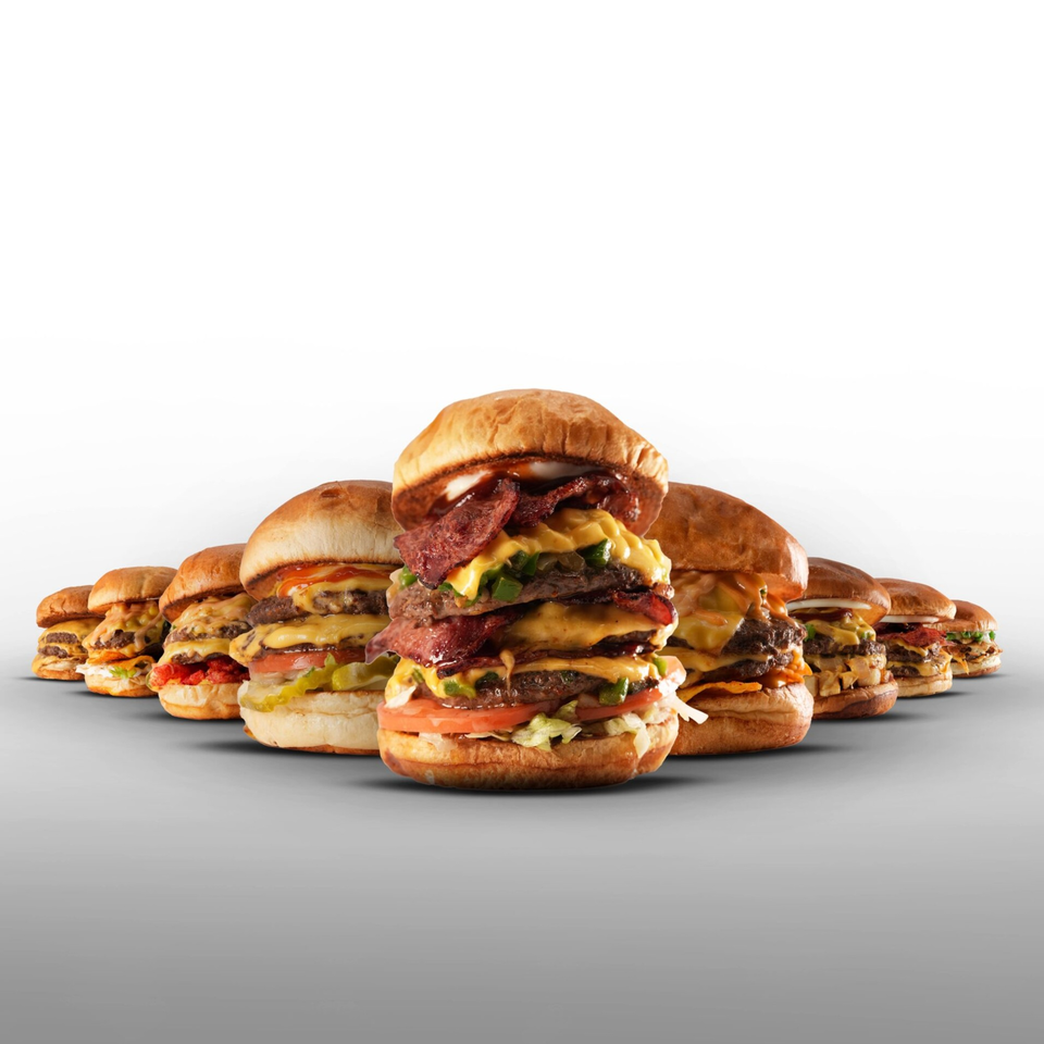 A line of various Burger Truck burgers, with a large, stacked burger in the foreground.