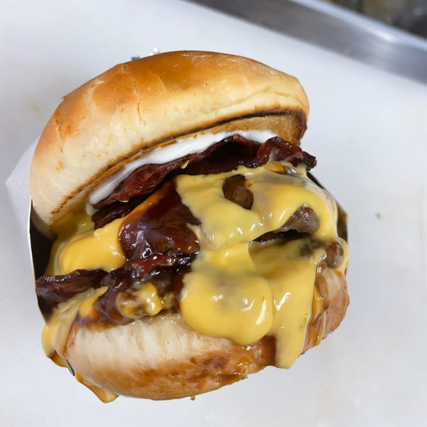 A double cheeseburger from The Burger Truck, with melted cheese, bacon, and sauce.