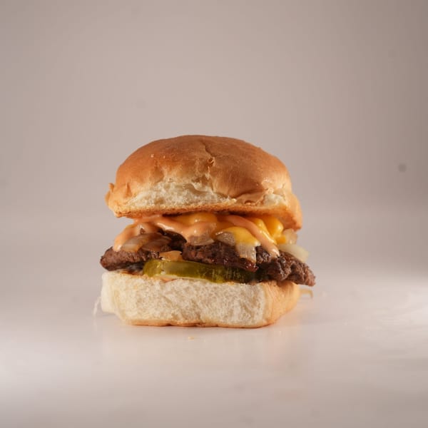 A Burger Truck burger with a patty, melted cheese, onions, pickles, and special sauce on a bun.