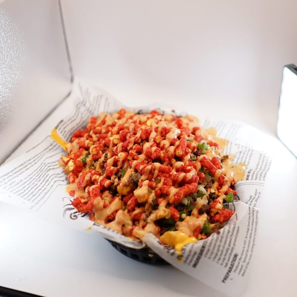 A basket of The Burger Truck's loaded nachos, topped with ground beef, cheese, and Cheetos.