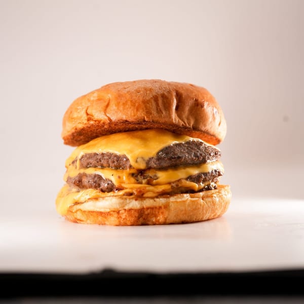 A double cheeseburger from The Burger Truck with melted cheese on a toasted bun.