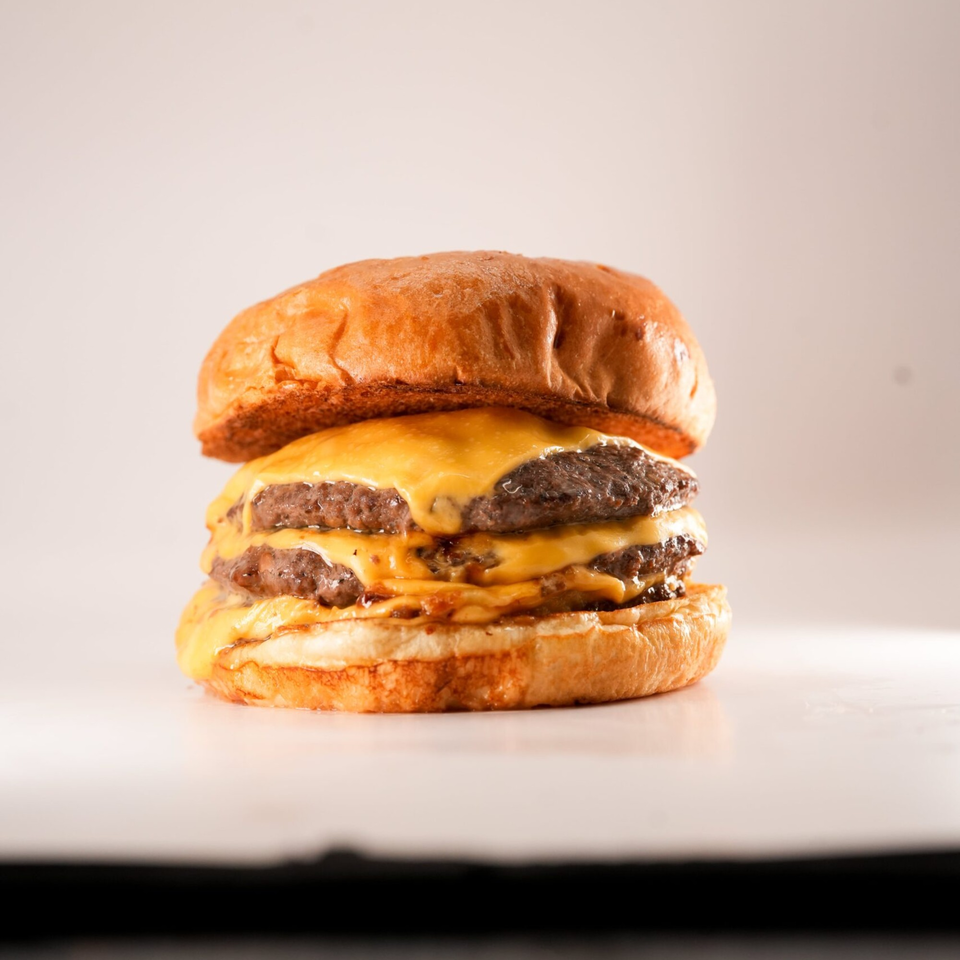 A double cheeseburger from The Burger Truck with melted cheese on a toasted bun.