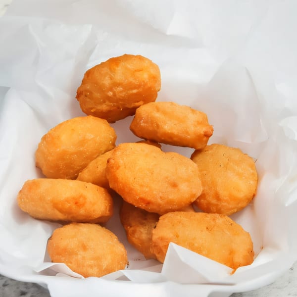 Golden-brown chicken nuggets from The Burger Truck, served in a white paper-lined basket.